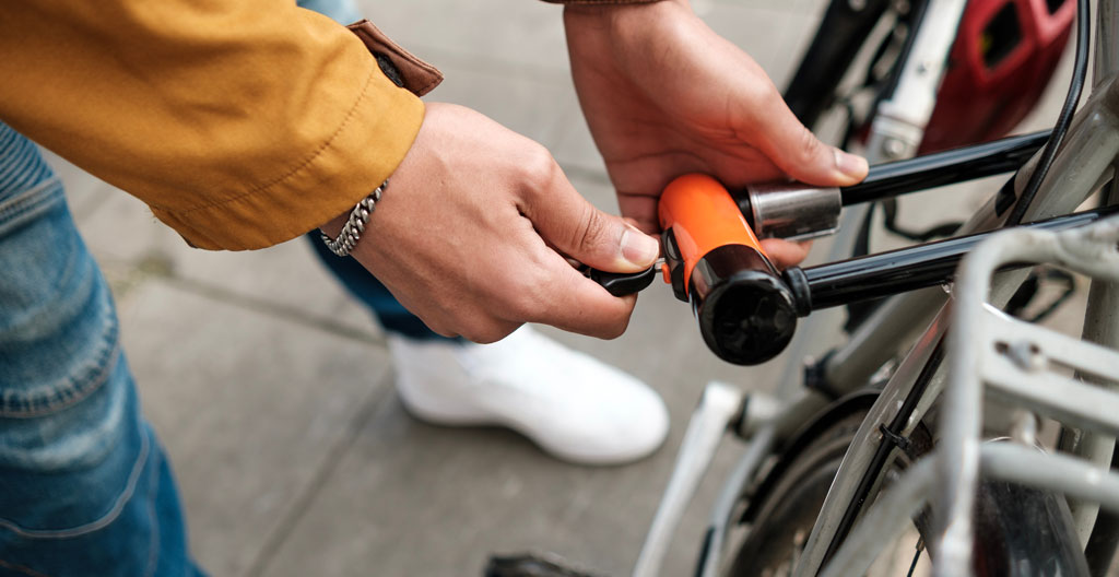 Gros plan sur un antivol en U noir mat attaché au cadre d'un vélo avec détail de la serrure cylindrique et arrière-plan flouté